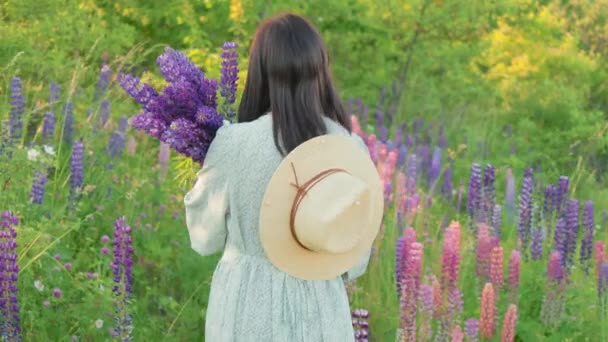 Visão Traseira Mulher Jovem Vestido Chapéu Com Flores Tremoço Buquê — Vídeo de Stock
