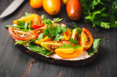 Ekmek, peynir, roka, maydanoz ve domatesli sağlıklı vejetaryen sandviçi..