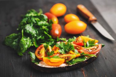 Ekmek, peynir, roka, maydanoz ve domatesli sağlıklı vejetaryen sandviçi..