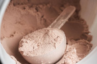 Bir kepçe çikolatalı süt proteini plastik bir kavanozda izole edilir..