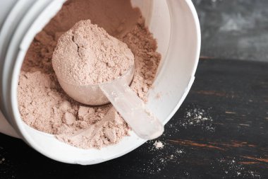 Bir kepçe çikolatalı süt proteini plastik bir kavanozda izole edilir..