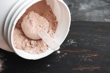 Bir kepçe çikolatalı süt proteini plastik bir kavanozda izole edilir..