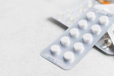 Beyaz arka plan, sağlık ve tıp konseptine sahip su toplayan ilaç ve tabletlerin yığını.