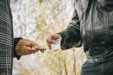 Erkek uyuşturucu satıcısı elinde parası olan, kırpılmış bir kadına şeffaf plastik torba içinde ağır uyuşturucu satıyor..
