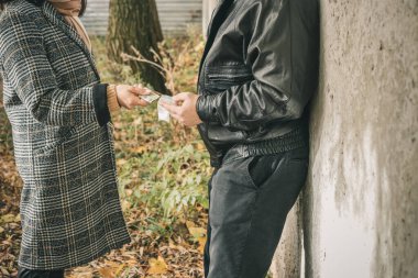 Erkek uyuşturucu satıcısı elinde parası olan, kırpılmış bir kadına şeffaf plastik torba içinde ağır uyuşturucu satıyor..