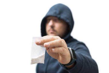 Kapüşonlu suçlu, beyaz arka planda izole edilmiş, şeffaf plastik torba ve sert uyuşturucular tutuyor. Uyuşturucu satıcısı ya da gangster uyuşturucu satıyor..