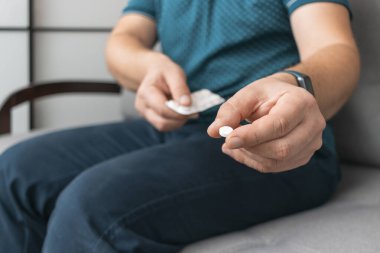 Su toplayıcıdan ilaç alan bir adam, elinde beyaz terapi hapı, antibiyotik, elinde ağrı kesici, yakın plan görüntüsü olan....