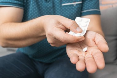 Su toplayıcıdan ilaç alan bir adam, elinde beyaz terapi hapı, antibiyotik, elinde ağrı kesici, yakın plan görüntüsü olan....