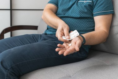 Su toplayıcıdan ilaç alan bir adam, elinde beyaz terapi hapı, antibiyotik, elinde ağrı kesici, yakın plan görüntüsü olan....