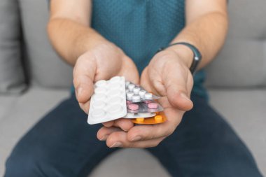 Tedavi için ilaç, antibiyotik ya da ağrı kesici içeren çeşitli su toplayan bir adam..