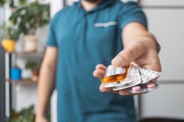 Tedavi için ilaç, antibiyotik ya da ağrı kesici içeren çeşitli su toplayan bir adam..