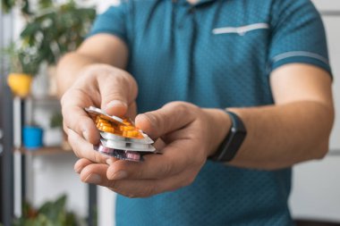 Tedavi için ilaç, antibiyotik ya da ağrı kesici içeren çeşitli su toplayan bir adam..