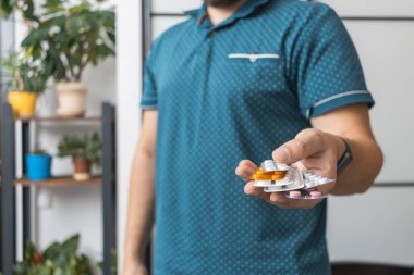 Tedavi için ilaç, antibiyotik ya da ağrı kesici içeren çeşitli su toplayan bir adam..