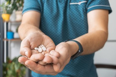 Elinde çeşitli tedavi hapları, antibiyotikler, ağrı kesici, ilaç, yakın çekim görüntüsü olan bir adam..