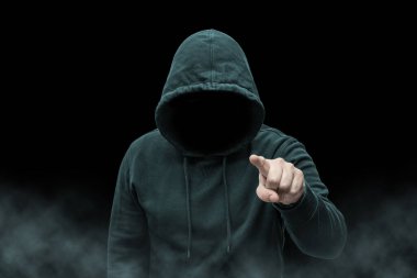 Gizemli yüzsüz isimsiz suçlu, bilgisayar korsanı silueti, siber terörist ya da siyah arka planda dumanlı gangster.