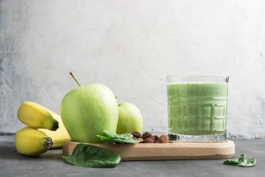 Bardakta yeşil detoks smoothie, ıspanak yaprakları, elma, muz ve fındık, sağlıklı beslenme konseptinden karışık vejetaryen içeceği..