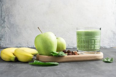 Bardakta yeşil detoks smoothie, ıspanak yaprakları, elma, muz ve fındık, sağlıklı beslenme konseptinden karışık vejetaryen içeceği..