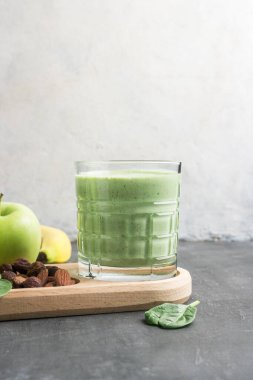 Bardakta yeşil detoks smoothie, ıspanak yaprakları, elma, muz ve fındık, sağlıklı beslenme konseptinden karışık vejetaryen içeceği..