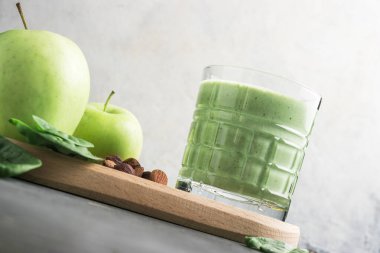 Bardakta yeşil detoks smoothie, ıspanak yaprakları, elma, muz ve fındık, sağlıklı beslenme konseptinden karışık vejetaryen içeceği..