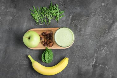 Bardakta yeşil detoks smoothie, ıspanak yaprakları, elma, muz ve fındık karışımı koyu fındık, sağlıklı beslenme konsepti, üst görünüm..