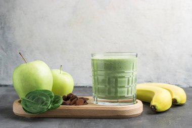 Bardakta yeşil detoks smoothie, ıspanak yaprakları, elma, muz ve fındık, sağlıklı beslenme konseptinden karışık vejetaryen içeceği..