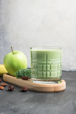 Bardakta yeşil detoks smoothie, ıspanak yaprakları, elma, muz ve fındık, sağlıklı beslenme konseptinden karışık vejetaryen içeceği..