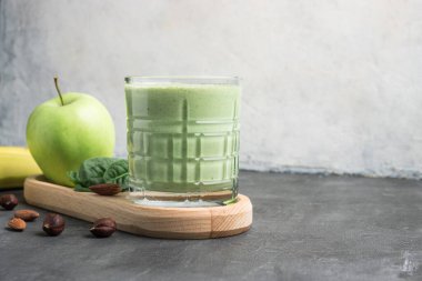 Bardakta yeşil detoks smoothie, ıspanak yaprakları, elma, muz ve fındık, sağlıklı beslenme konseptinden karışık vejetaryen içeceği..