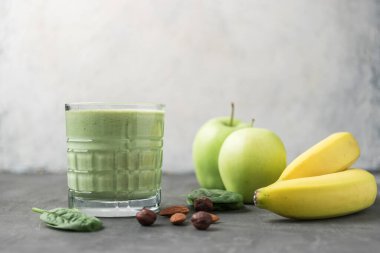 Bardakta yeşil detoks smoothie, ıspanak yaprakları, elma, muz ve fındık, sağlıklı beslenme konseptinden karışık vejetaryen içeceği..