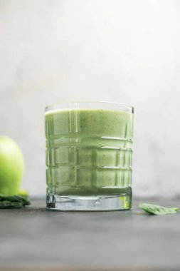 Bardakta yeşil detoks smoothie, ıspanak yaprakları ve elmadan karışık vejetaryen içeceği, sağlıklı beslenme konsepti..