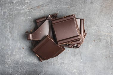 Lezzetli siyah çikolata parçacıkları ya da küp şeklinde, siyah arka planda parçalanmış çikolata.