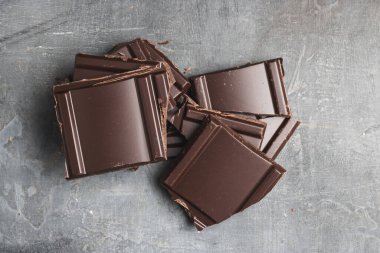 Lezzetli siyah çikolata parçacıkları ya da küp şeklinde, siyah arka planda parçalanmış çikolata.