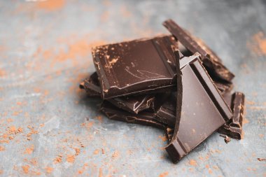 Lezzetli siyah çikolata parçacıkları ya da küp şeklinde siyah bir arka planda parçalanmış çikolata..