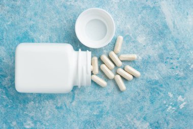 Mavi arka plan, vitamin ve mineraller, besin veya beslenme takviyesi, üst görünüm.