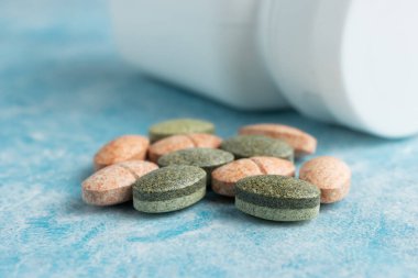Mavi arka plan, vitamin ve mineraller, besin veya beslenme takviyesi için çok renkli tıbbi ilaçlar, ilaçlar veya tabletler.