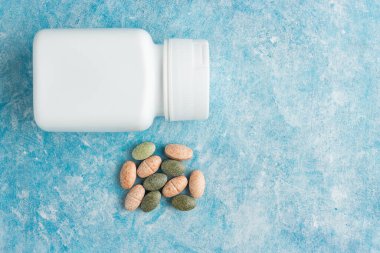 Mavi arka plan, vitamin ve mineraller, beslenme veya beslenme takviyesi, üst görünüm.