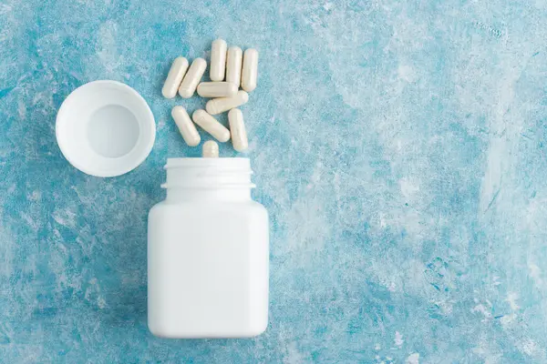 Mavi arka plan, vitamin ve mineraller, besin veya beslenme takviyesi, üst görünüm.