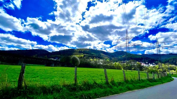 Сельская Местность Зеленая Трава Большие Горы Голубым Небом Яркими Облаками — стоковое фото