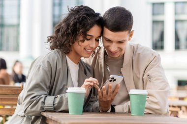 Bir kafede mutlu bir çift. Telefona bakıyor, gülümsüyor, konuşuyor, masada kahve içiyor. Sonbahar atmosferi