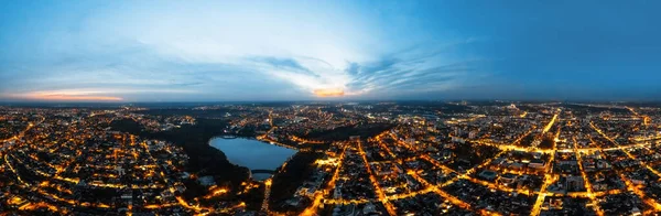 stock image Aerial drone view of Chisinau at sunset. Panorama view of multiple buildings, bare trees, park, lake and clear sky. Moldova