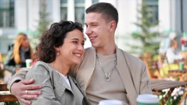 Bir kafede mutlu bir çift. Sarılmak, öpüşmek, gülümsemek ve konuşmak, kahve. Sonbahar atmosferi