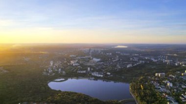 Chisinau 'nun günbatımında Moldova' da hava aracı görüntüsü. Yeşillik ve gölle dolu Valea Morilor Parkı. Birden fazla binanın panoramik görüntüsü