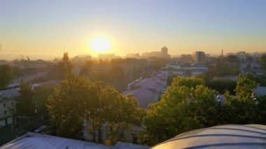 Chisinau 'nun güneş doğarken, Moldova' daki hava aracı görüntüsü. Şehir merkezi sisle kaplı, birden fazla bina, yeşillik, Parlak Güneş