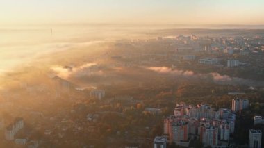 Chisinau 'nun güneş doğarken, Moldova' daki hava aracı görüntüsü. Sis, birden fazla bina ve park ile kaplı şehir merkezi manzarası