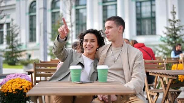 一对快乐的夫妇在外面的咖啡店附近 拥抱彼此 喝咖啡 秋天的气氛慢动作 — 图库视频影像