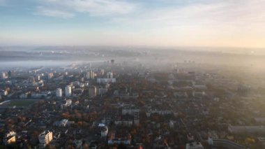 Chisinau 'nun güneş doğarken, Moldova' daki hava aracı görüntüsü. Gökyüzü sisli, binalar, meydanlar ve caddeler sararmış ağaçlarla kaplı.