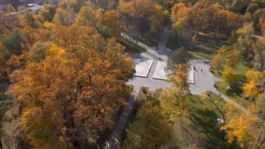Moldova 'nın Chisinau kentindeki bir meydanın insansız hava aracı görüntüsü. Sarı ağaçlarla dolu park, dinlenen insanlar.
