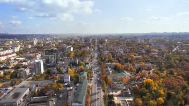 Moldova, Chisinau 'nun hava aracı görüntüsü. Şehir merkezinin birden fazla binası, Dendrarium parkı ve sarı ağaçlı caddeleri manzarası