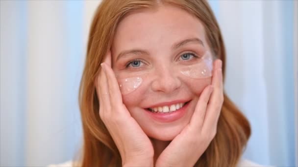 若い白人の笑顔の女性が顔マスクを作っている — ストック動画