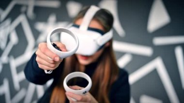 VR oyunlarıyla ilgilenen genç bir kadın VR gözlük ve kumanda kullanıyor. Yavaş çekim