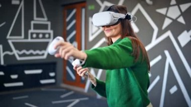 VR oyunlarıyla ilgilenen genç bir kadın VR gözlük ve kumanda kullanıyor. Yavaş çekim